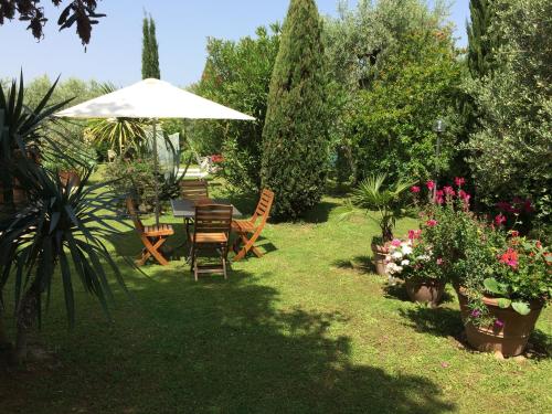 a garden with a table and chairs and an umbrella at La casa dei nonni in Larciano