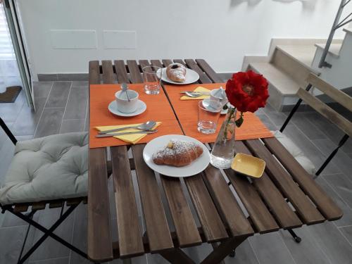 a wooden table with plates of food and a vase of flowers at L'Antico Borgo B&B in Noto