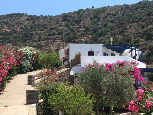 a house with flowers in front of a mountain at Villa Costa Studios in Vathi, Sifnos