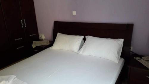 a bed with two white pillows in a bedroom at Gakis in Loutsa