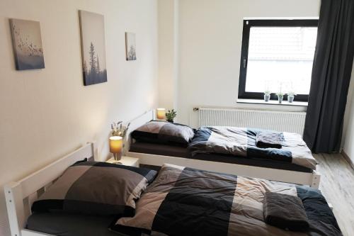 2 Betten in einem Schlafzimmer mit Fenster in der Unterkunft Zentrales Apartment mit Dachterrasse in Goch