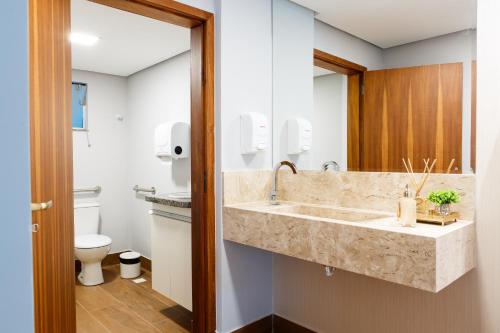 a bathroom with a sink and a toilet at Dr. Marinho Apart Hotel in Vitória da Conquista