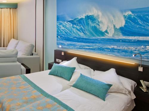 a bedroom with a large wave painting on the wall at Hotel Villa del Mar in Benidorm