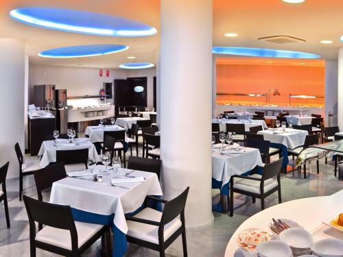 a dining room with white tables and chairs at Hotel Villa del Mar in Benidorm