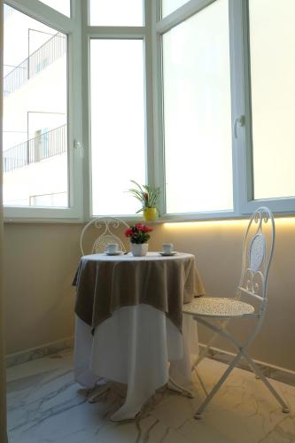 a table and two chairs in a room with windows at PVrooms in Campobasso