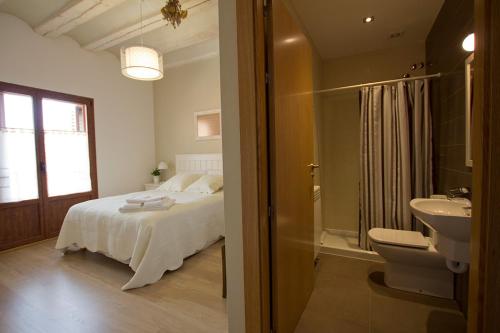 a bedroom with a bed and a sink and a bathroom at Casa Rural Villazón II - A 16 km de Pamplona in Obanos
