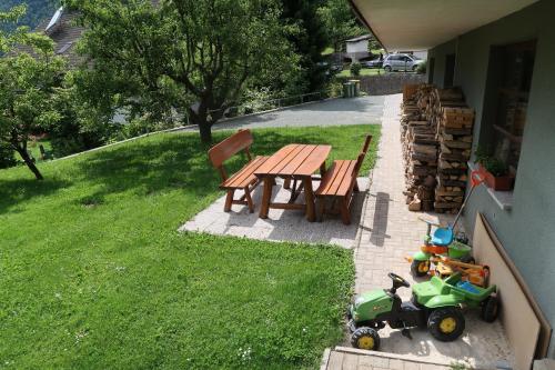 a picnic table and a toy tractor next to a picnic table and a lawn at Rooms Zupančič in Bohinjska Bela