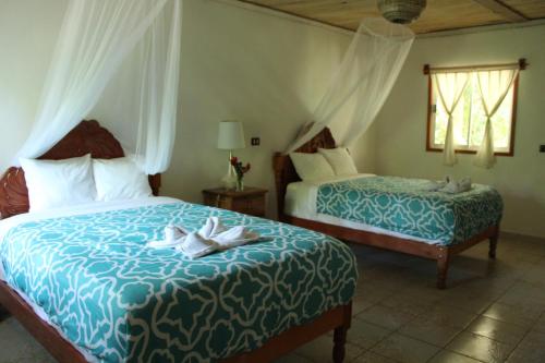 a hotel room with two beds and a window at Topche, Centro Ecoturístico in Lacanjá