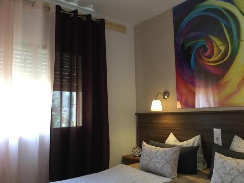 1 dormitorio con 1 cama y una pintura en la pared en Apartman Dénia, en Denia