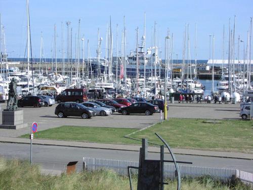 a group of cars parked in a marina with boats at Skagen Apartment in Skagen