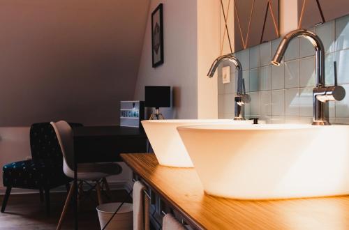 a bathroom with two sinks and a desk at Hotel Palmenbad in Kassel