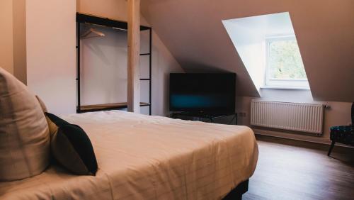 a bedroom with a bed and a flat screen tv at Hotel Palmenbad in Kassel