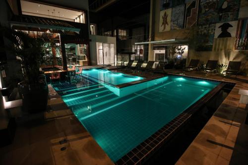 a large swimming pool with green lights on it at Hotel da Praça in Bonito