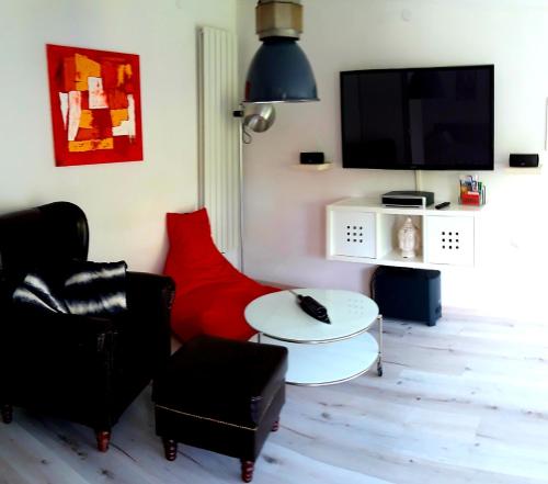 a living room with two chairs and a tv at Arthouse Apartment 2 in Bad Vilbel