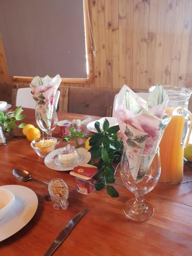 a wooden table with two wine glasses with napkins at Sevens Guesthouse in Kroonstad