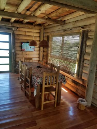 a dining room with a table and chairs in a log cabin at La Porteña in Gualeguaychú