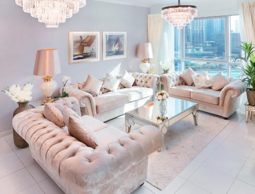 a living room with two couches and a chandelier at Elite Royal Apartment - T3 - Full Burj Khalifa & fountain view in Dubai