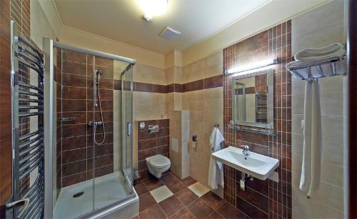 a bathroom with a shower toilet and a sink at Penzion Club in Skalica