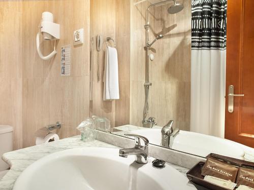 a bathroom with a sink and a toilet and a mirror at Magic Aqua Rock Gardens in Benidorm