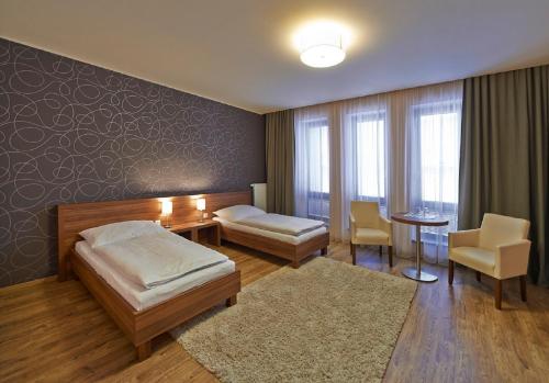 a bedroom with a bed and a table and chairs at Penzion Club in Skalica