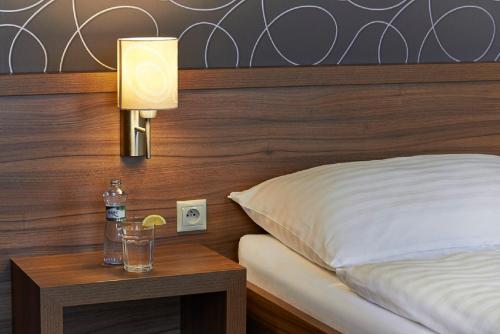 a bedroom with a bed and a lamp on a table at Penzion Club in Skalica