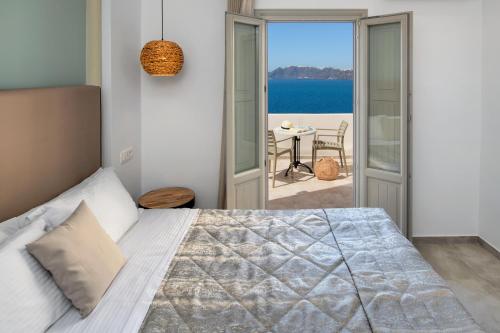 a bedroom with a bed and a view of the ocean at Kokkinos Villas in Akrotiri