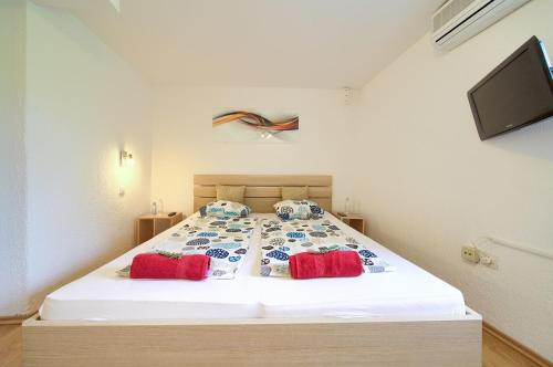 a bedroom with a bed with two red pillows at Holiday Home Traum in Krk