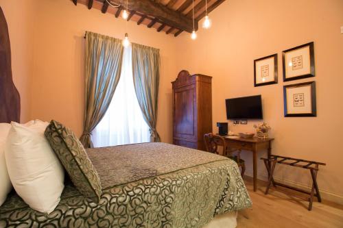 a bedroom with a bed and a window and a desk at Le Camere Di Boccanegra in Sarzana