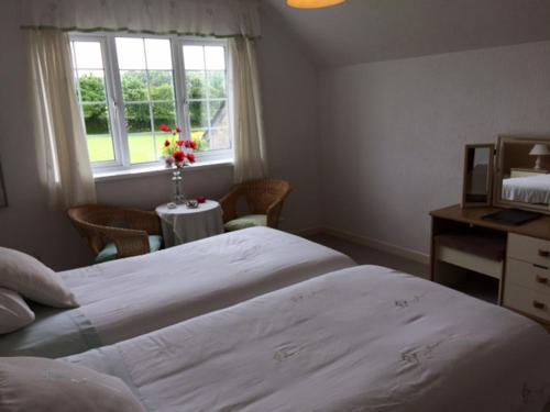 HolbetonにあるThe Grange Accommodation, Waye Farm, Ermington, Devonのベッドルーム1室(大型ベッド1台、窓付きテーブル付)