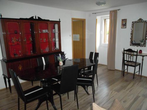 a dining room with a table and chairs and a red cabinet at Hodak Apartment in Nerezine