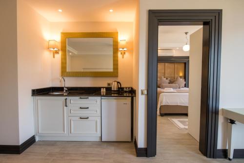 a bathroom with a sink and a bedroom with a bed at The Mediteran Hotel in Kalkan