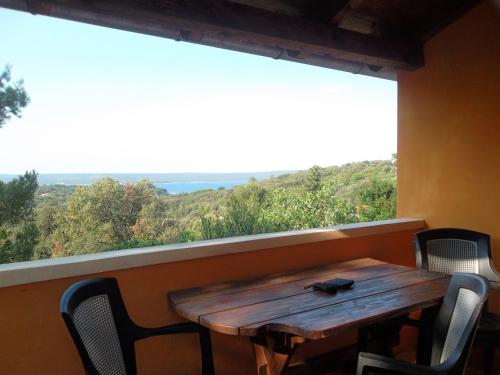 a wooden table and chairs in a room with a large window at Hodak Apartment in Nerezine