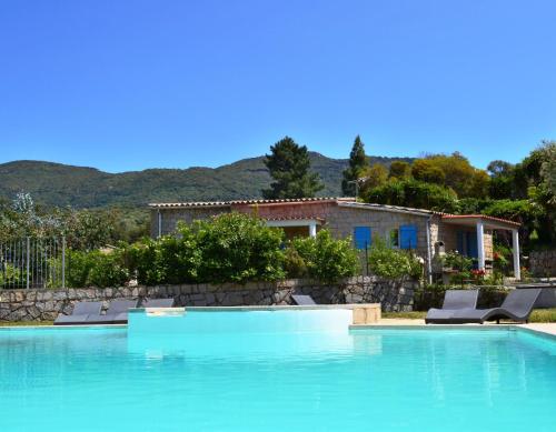 a swimming pool with chairs and a house at Résidence de Filitosa - Le Torréen in Sollacaro