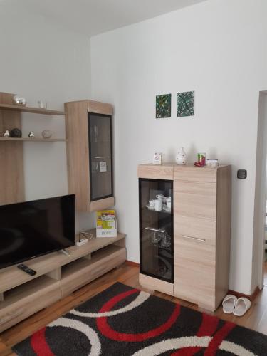 a living room with a tv and a entertainment center at Privat Zimmer KF in Knittelfeld