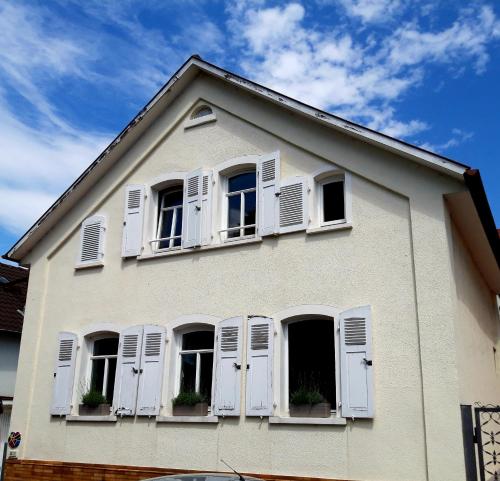 a white house with white windows and shutters at Arthouse Apartment 2 in Bad Vilbel