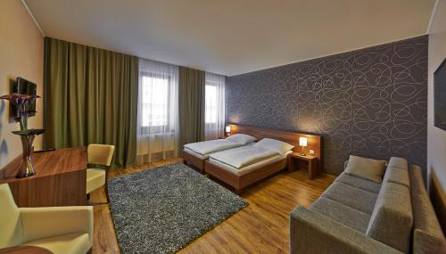 a hotel room with a bed and a couch at Penzion Club in Skalica