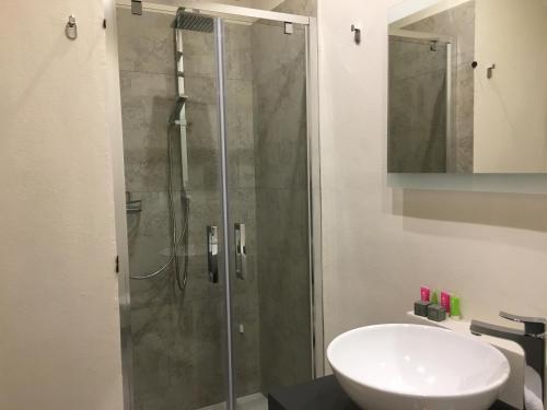 a bathroom with a glass shower and a sink at Dimora Conte in La Maddalena