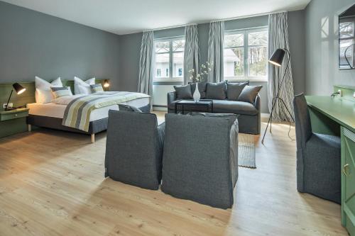a bedroom with a bed and a living room at Upstalsboom Hotel Trassenheide in Trassenheide