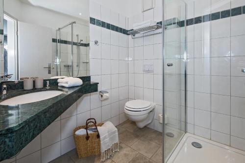 e bagno con servizi igienici, lavandino e doccia. di Upstalsboom Hotel Strandidyll a Trassenheide