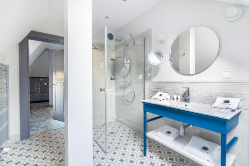 a bathroom with a blue sink and a shower at Villa Testa in Sopot