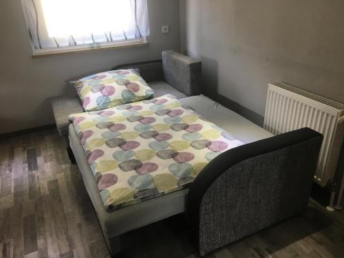 a bed with a quilt on it in a room at Ferienwohnung Pedall in Bischofsgrün
