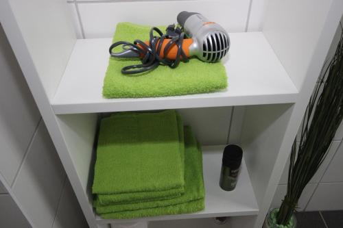 a shelf with green towels and a lamp on it at Ferienwohnung Pedall in Bischofsgrün