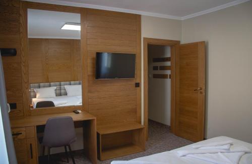 a bedroom with a desk and a bed and a television at Prince Cyril Hotel in Nesebar