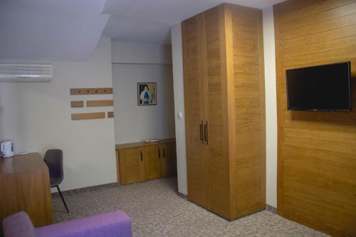 a room with a large wooden closet with a flat screen tv at Prince Cyril Hotel in Nesebar