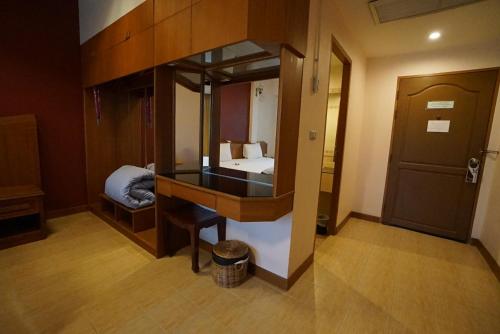 a room with a mirror and a bed in it at Country Lake View Hotel in Suphan Buri
