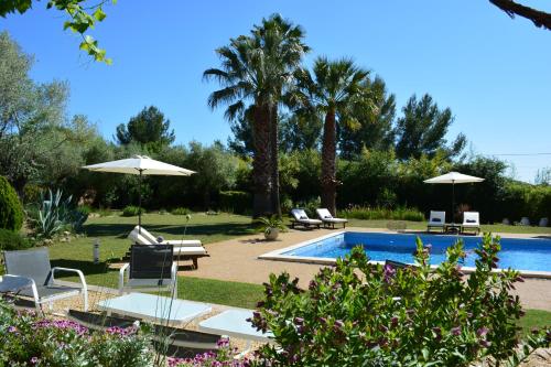 une piscine avec chaises et parasols dans une cour dans l'établissement O Chai d'Oeuvres - Charming B&B - Adults only, à Campagnan