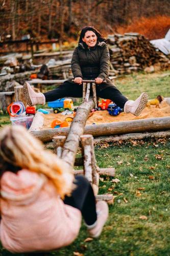 a woman sitting on a log in a park at Chata u Cecila in Loučná nad Desnou