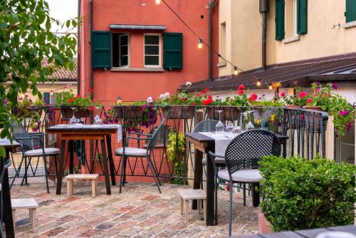 an outdoor patio with tables and chairs and flowers at La locanda del Povero Diavolo in Torriana