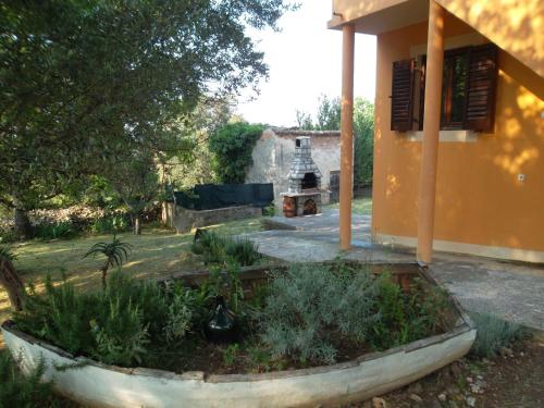 a garden in front of a house with a planter at Hodak Apartment in Nerezine