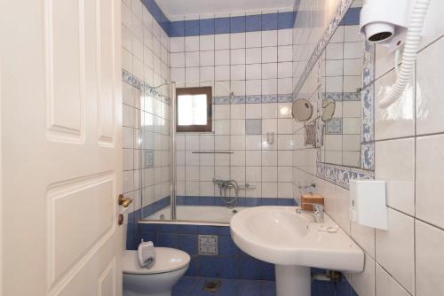 uma casa de banho com um lavatório, um WC e uma banheira em Methoni Beach Hotel em Modon